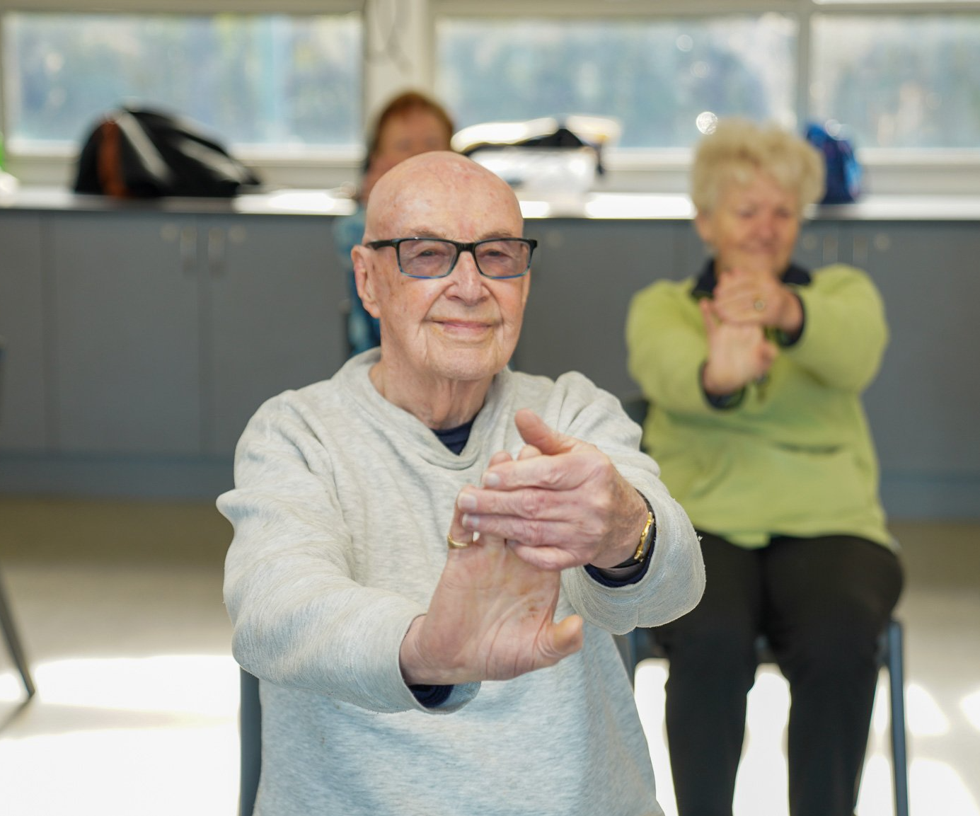 Man holding hand, stretching in chair