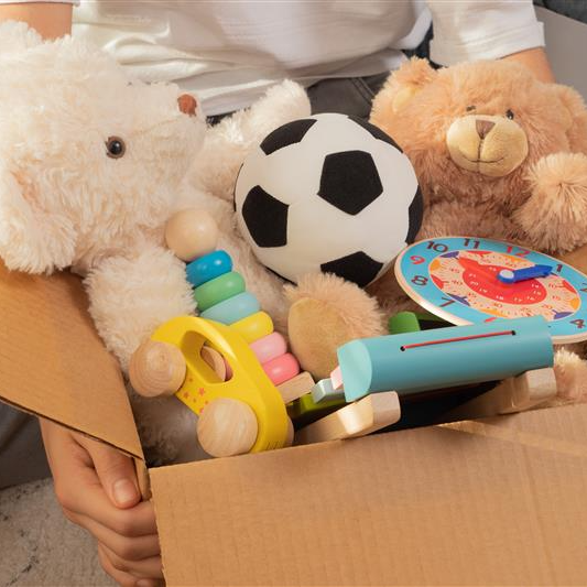 Hands holding box containing childrens toys