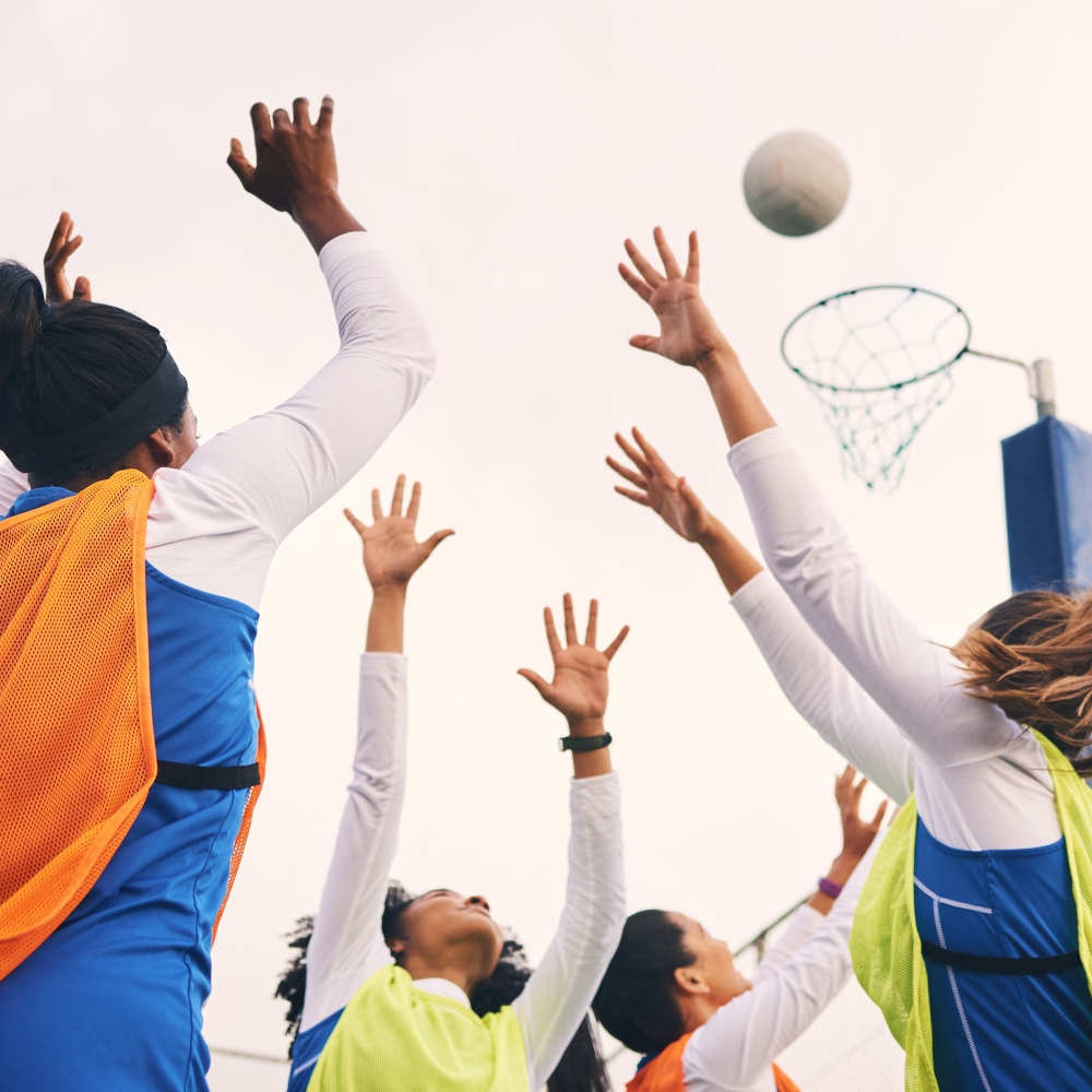 People with their hands in the air to catch a ball