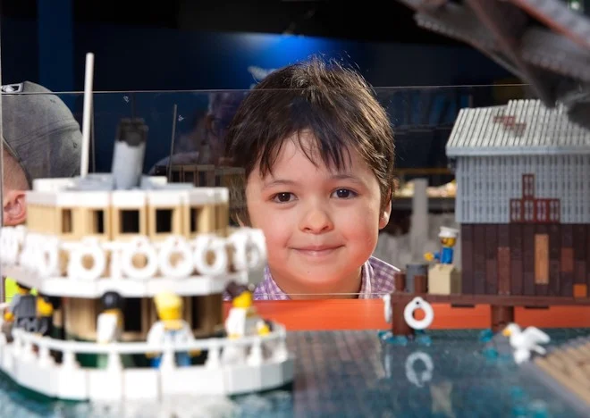 Little boy standing behind LEGO structures
